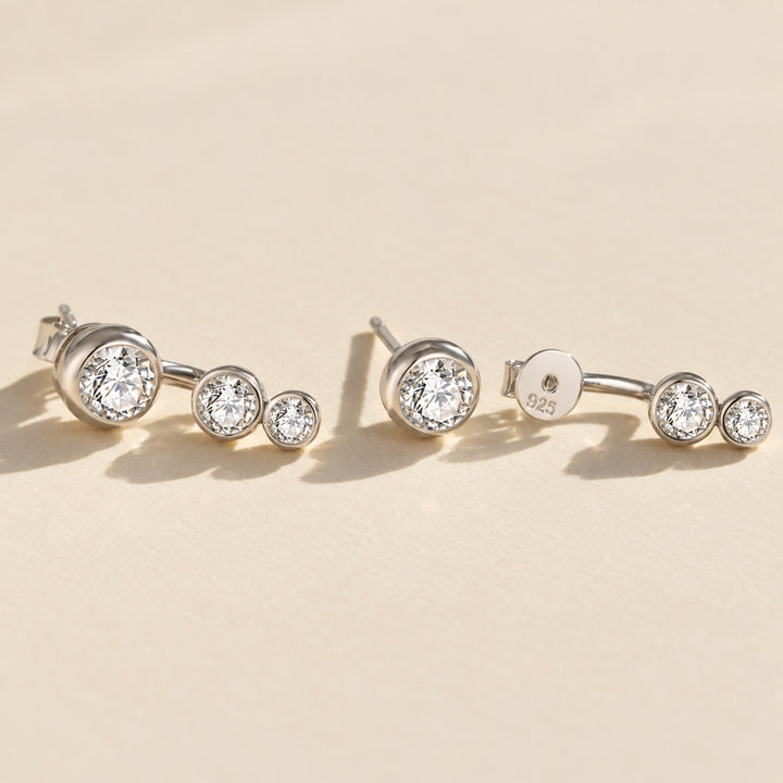 Silver three-stone moissanite ear jacket earrings showing the curved jacket design