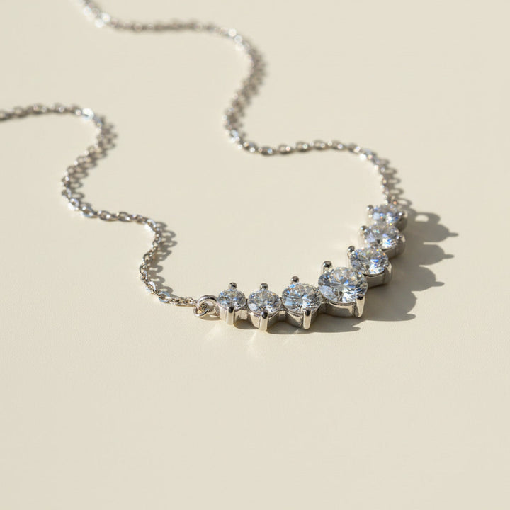 Silver necklace with moissanite stones on a beige background