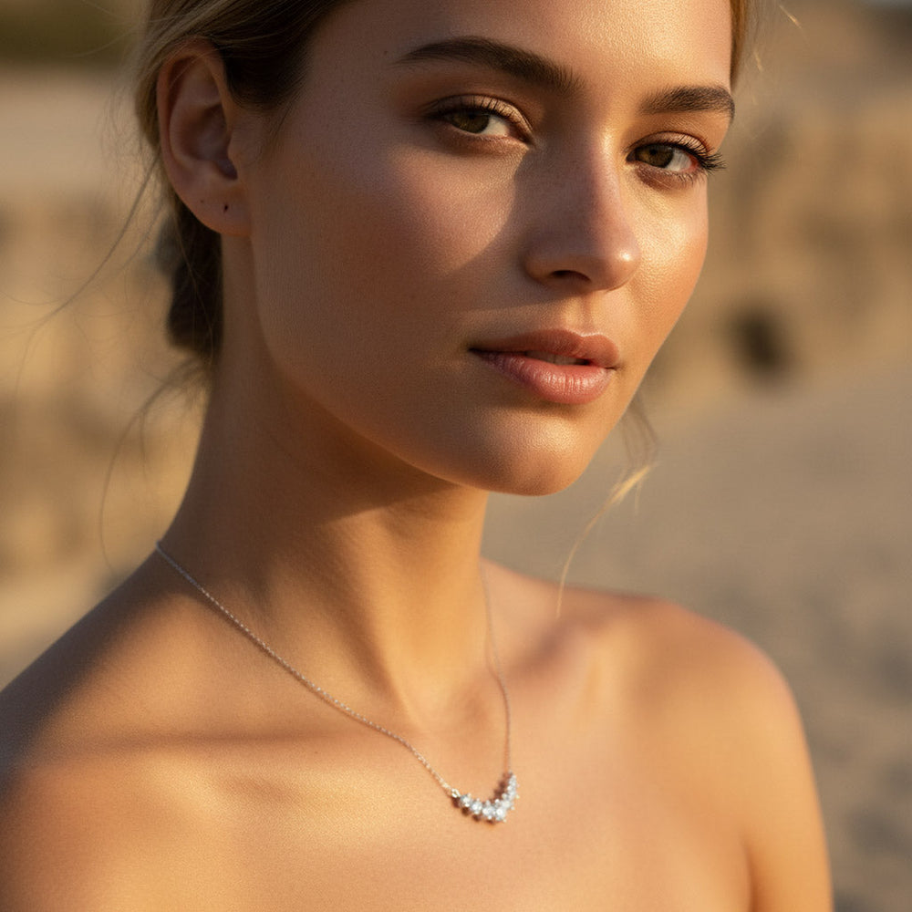 Close-up of a woman wearing a moissanite necklace with a blurred background