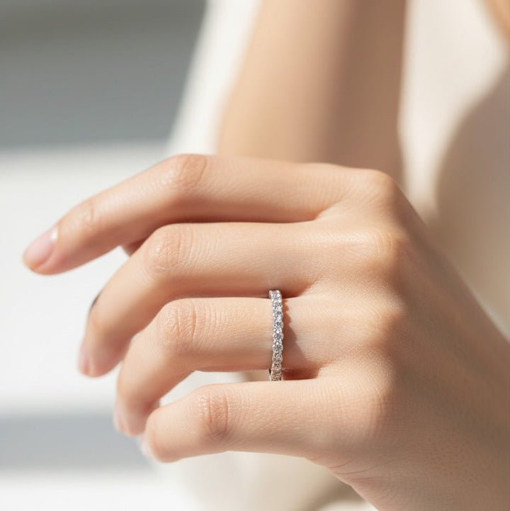 Model wearing sterling silver eternity band with seven lab-grown diamonds in claw settings