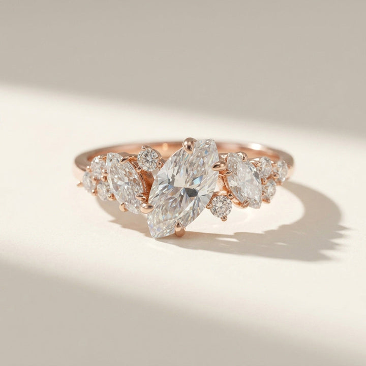Rose gold ring with pear-shaped diamonds on a light background