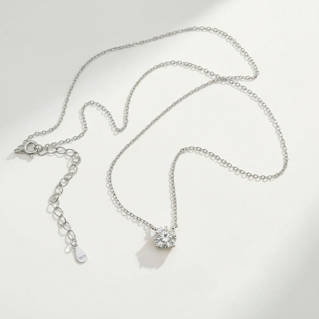 Platinum-plated sterling silver necklace featuring a round lab-grown moissanite solitaire pendant with 925 tag.