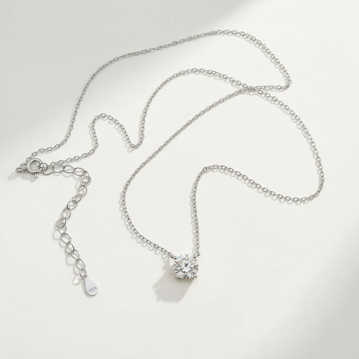 Platinum-plated sterling silver necklace featuring a round lab-grown moissanite solitaire pendant with 925 tag.
