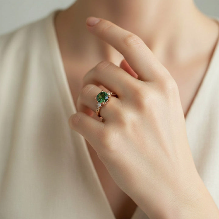 Green moissanite ring shown on hand with rose gold band