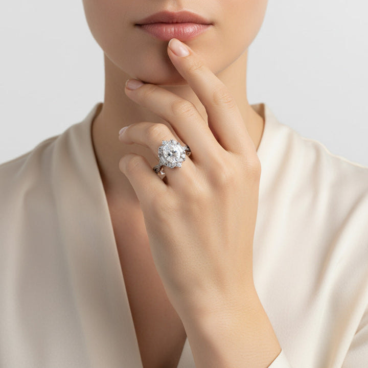 Close-up of a hand wearing a moissanite ring with a neutral background