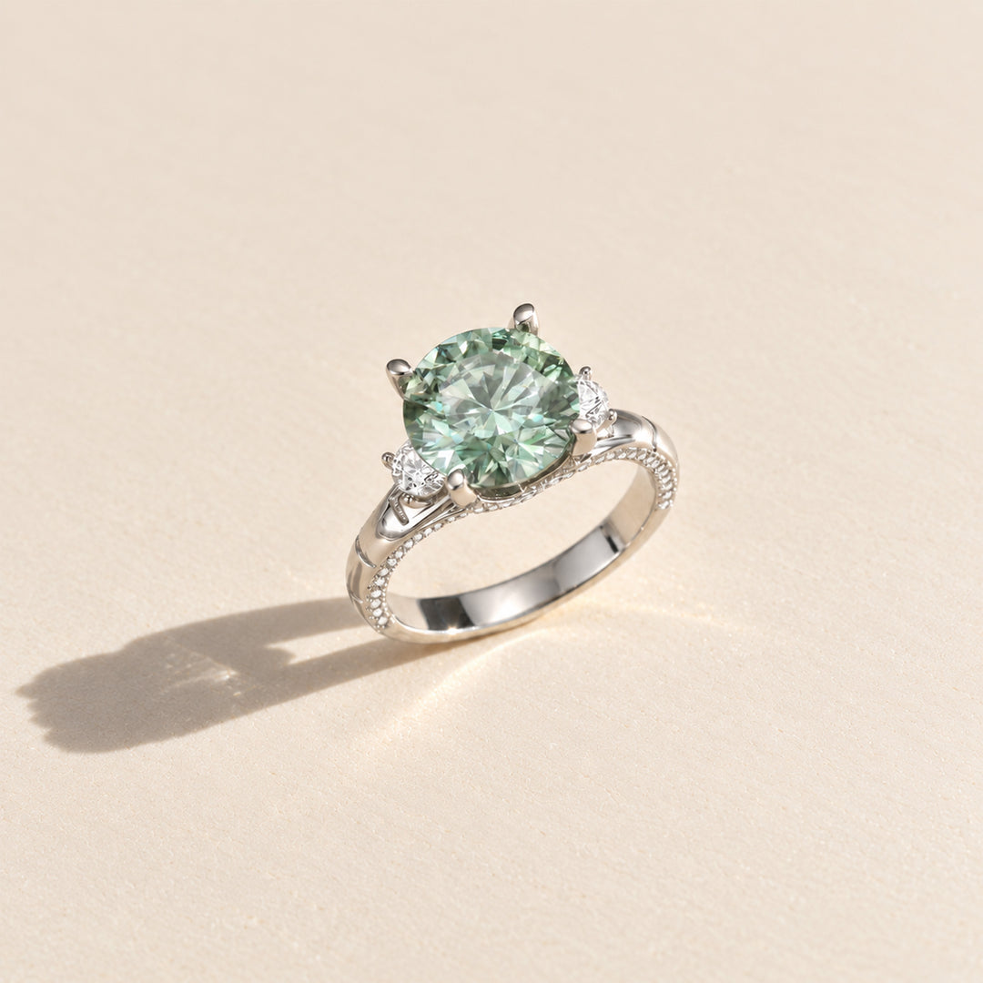 Three-quarter view of 5 carat green moissanite ring with white side stones and pavé sterling silver band