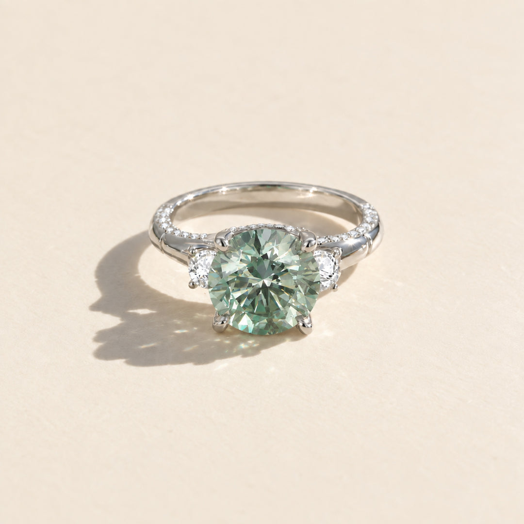 Front view of 5 carat round green moissanite ring with two white side stones