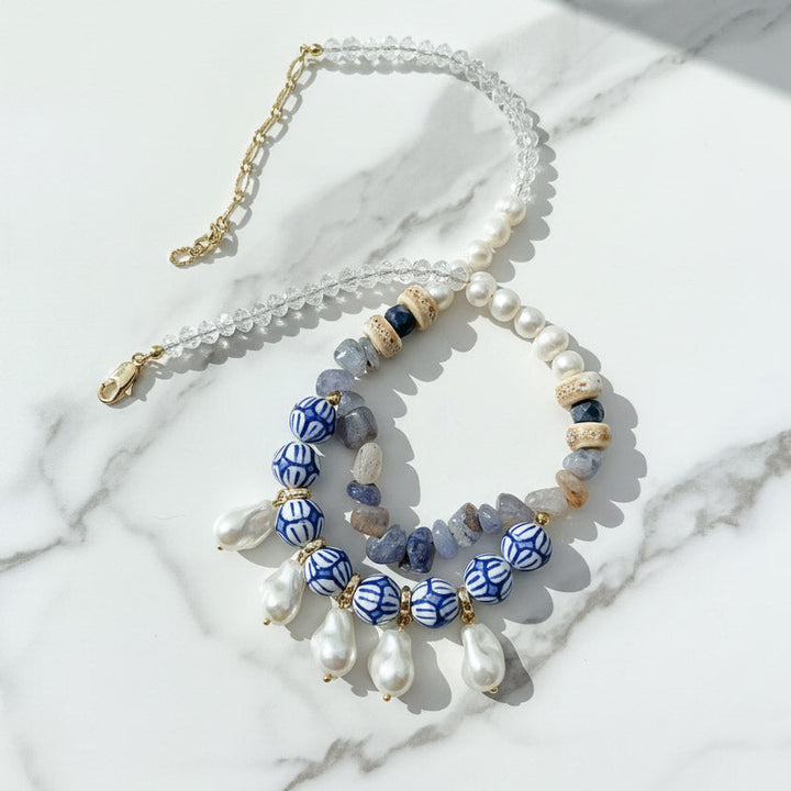 Artistic porcelain and pearl necklace with blue painted beads, freshwater pearls, and baroque drops.