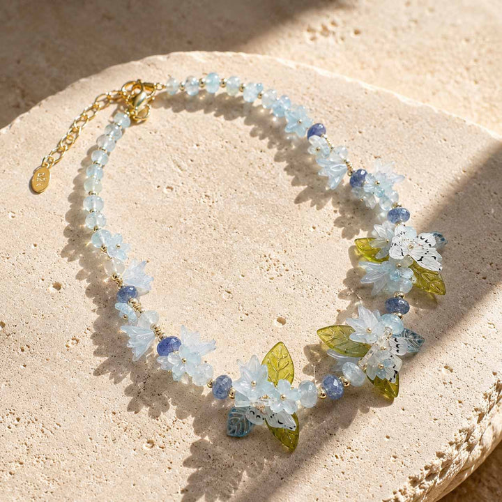 Necklace with floral and bead design on a beige stone surface