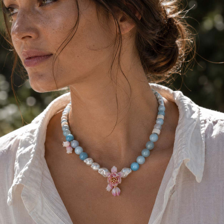 Woman Wearing Lotus Amazonite Necklace with Hand-Painted Lotus Flower, Mother of Pearl Flower Buds and Porcelain Beads