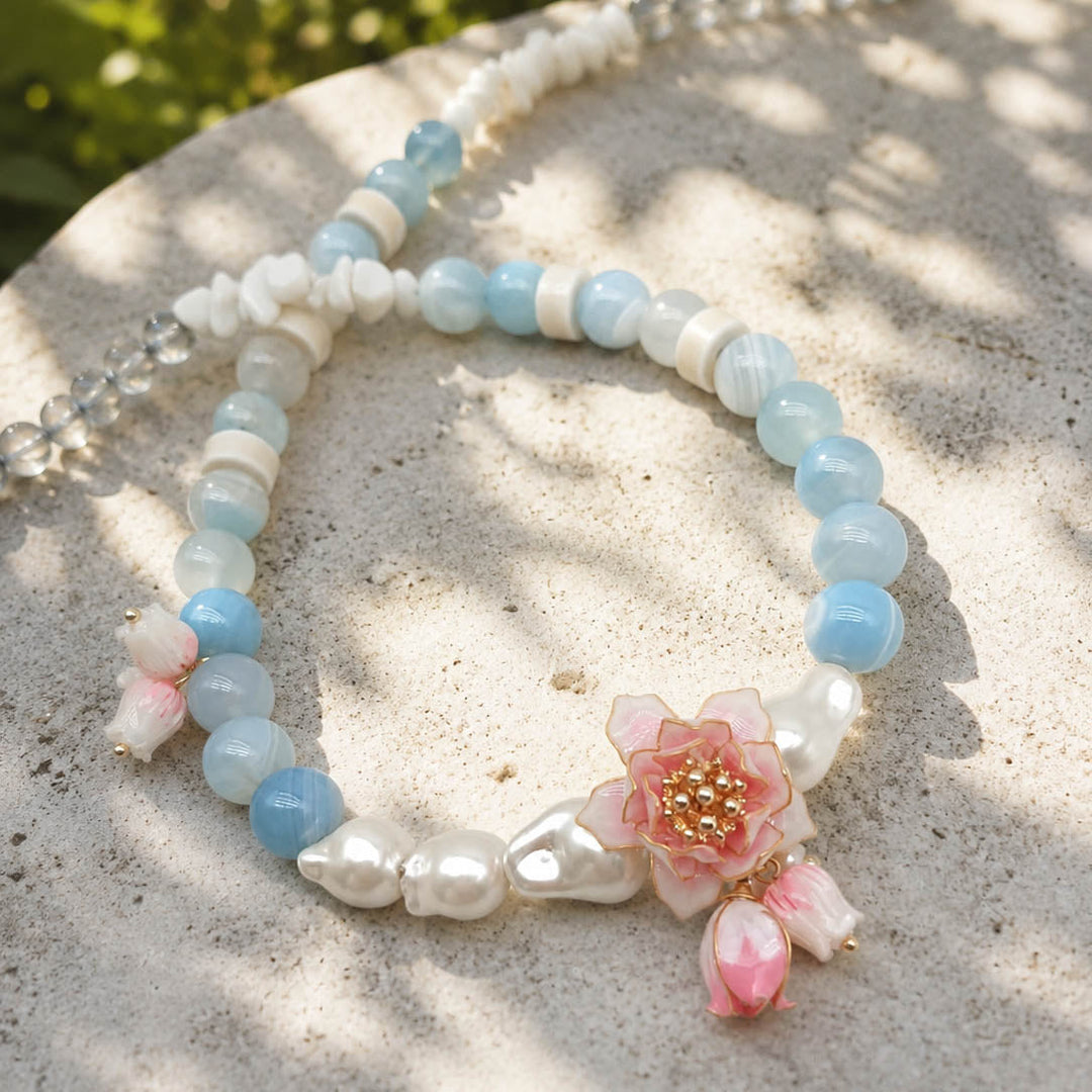 Botanical Lotus Necklace with Amazonite Stones on a sandy surface