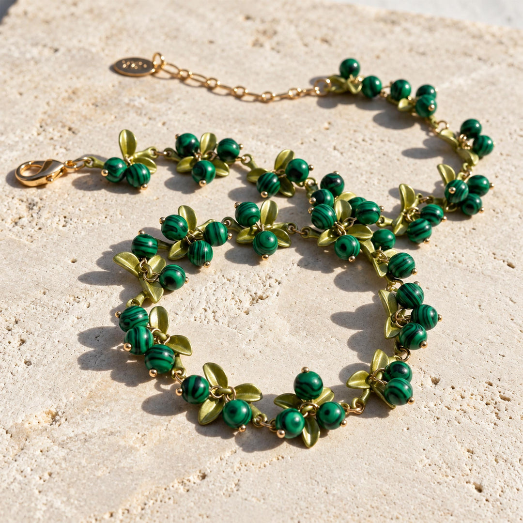 Malachite Berry Garden Necklace arranged on limestone showing green striped stones, enamel leaves and extender chain