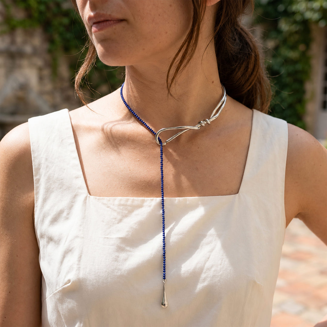 Model wearing Lapis Lazuli Curve Collar Necklace with blue gemstone drop and polished silver-tone collar