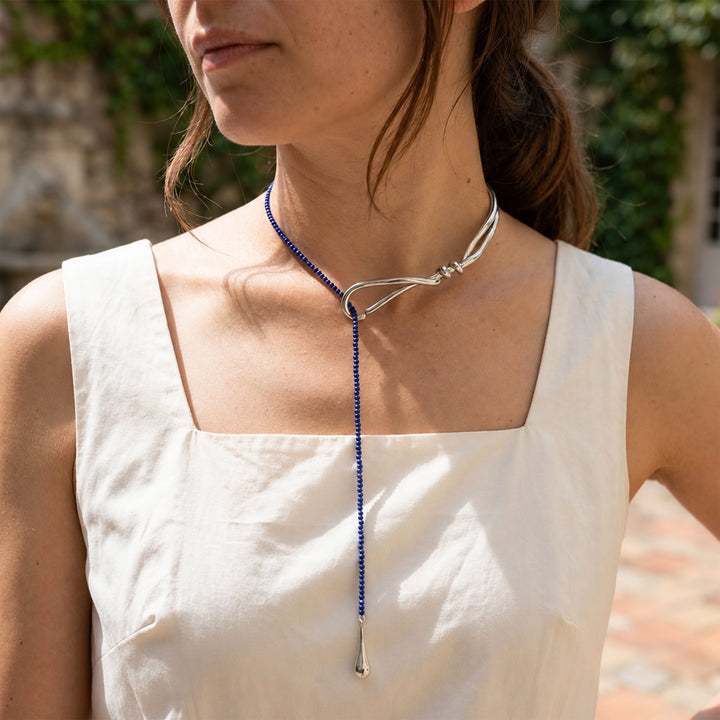 Model wearing Lapis Lazuli Curve Collar Necklace with blue gemstone drop and polished silver-tone collar