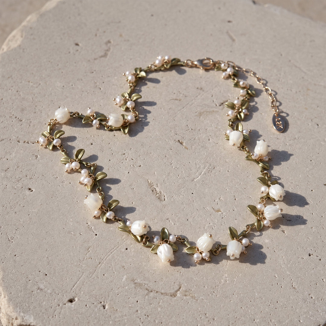Full Lily of the Valley necklace with hand-carved mother-of-pearl flowers, pearl accents and olive-green enamel leaves on stone.