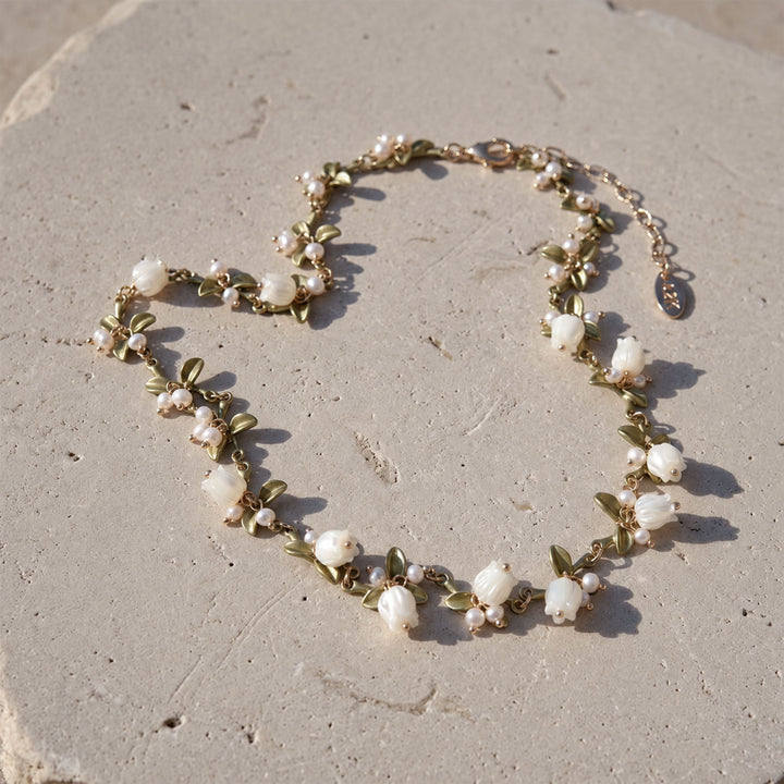 Full Lily of the Valley necklace with hand-carved mother-of-pearl flowers, pearl accents and olive-green enamel leaves on stone.