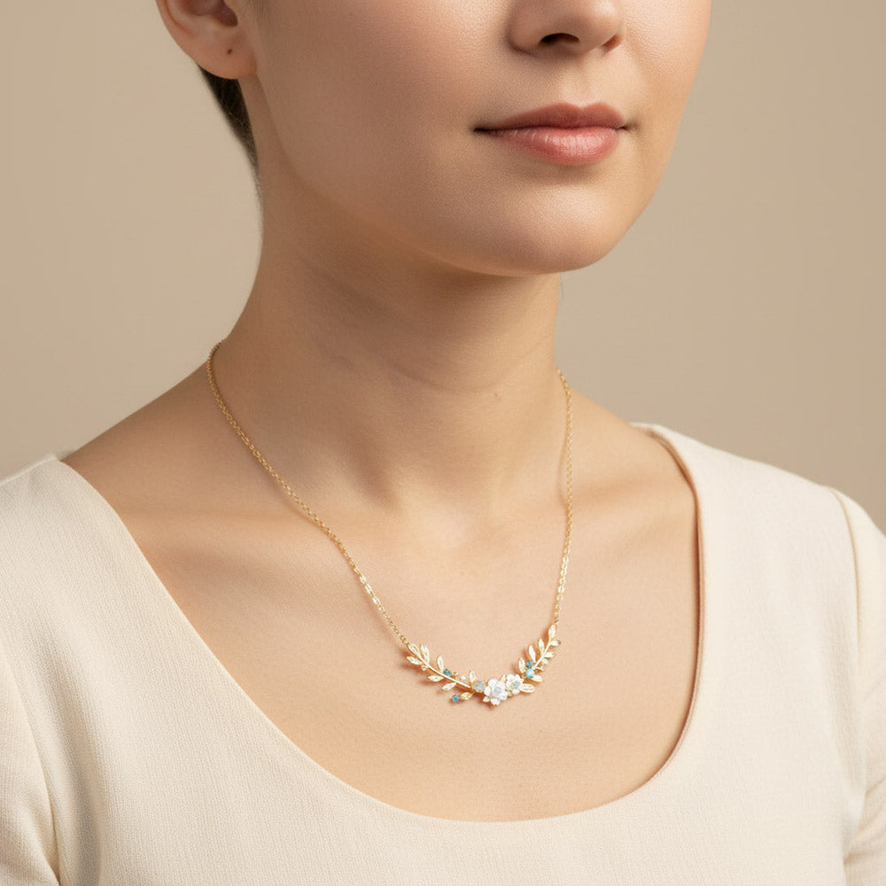 Necklace with floral design worn by a person against a neutral background