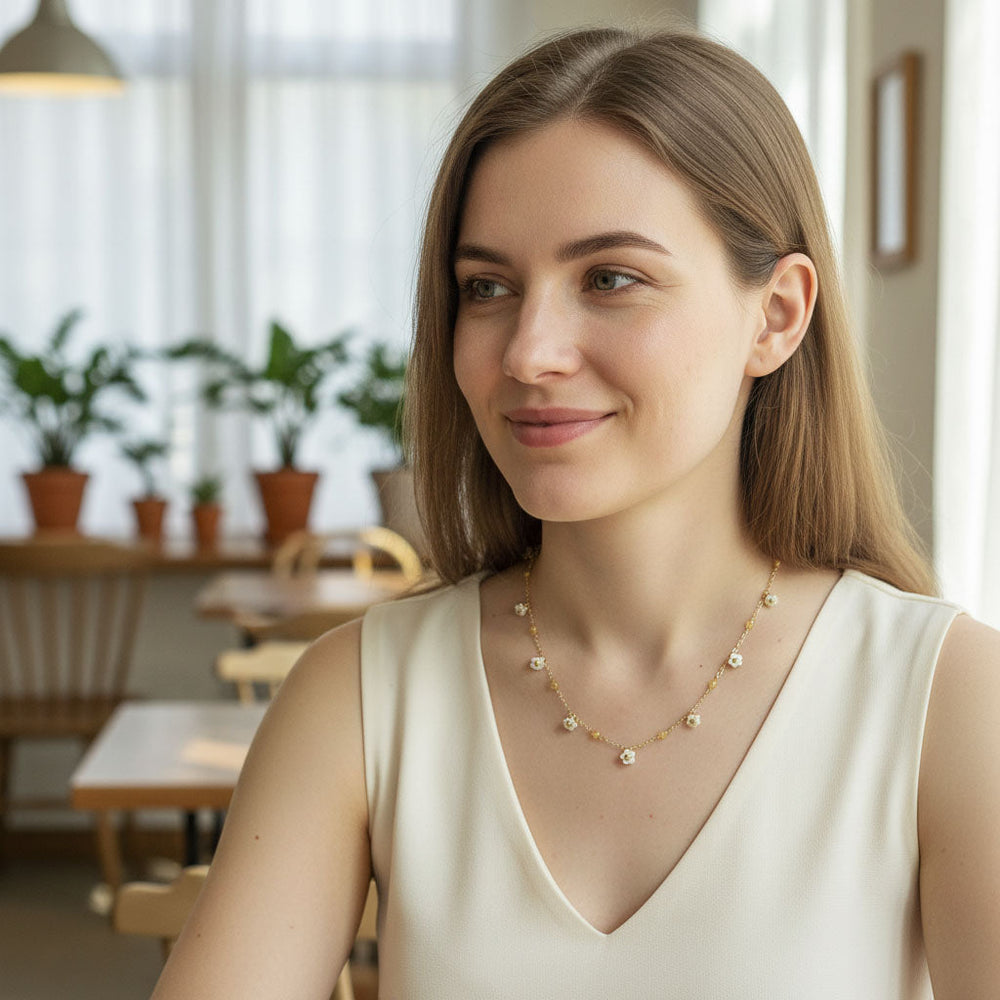 Woman wearing a necklace in a casual indoor setting with plants and furniture.