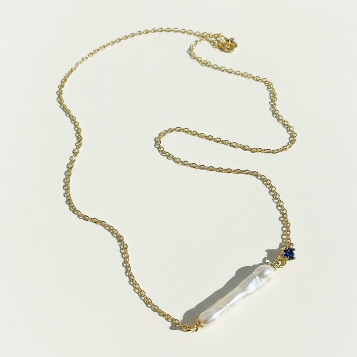 Gold necklace with a pendant on a light background