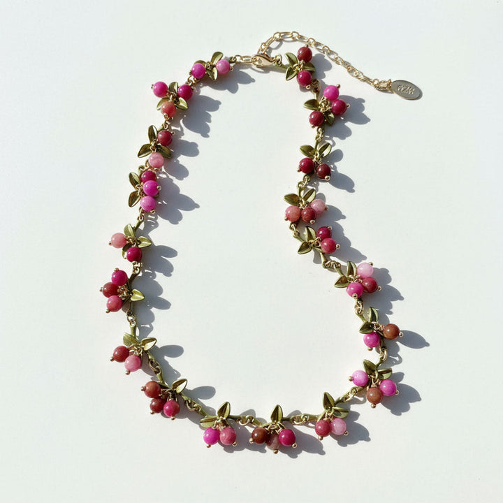 Necklace with pink and red beads on a white background