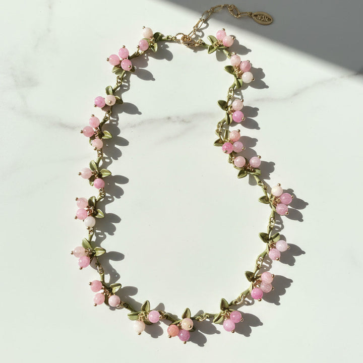 Necklace with pink floral beads on a light background