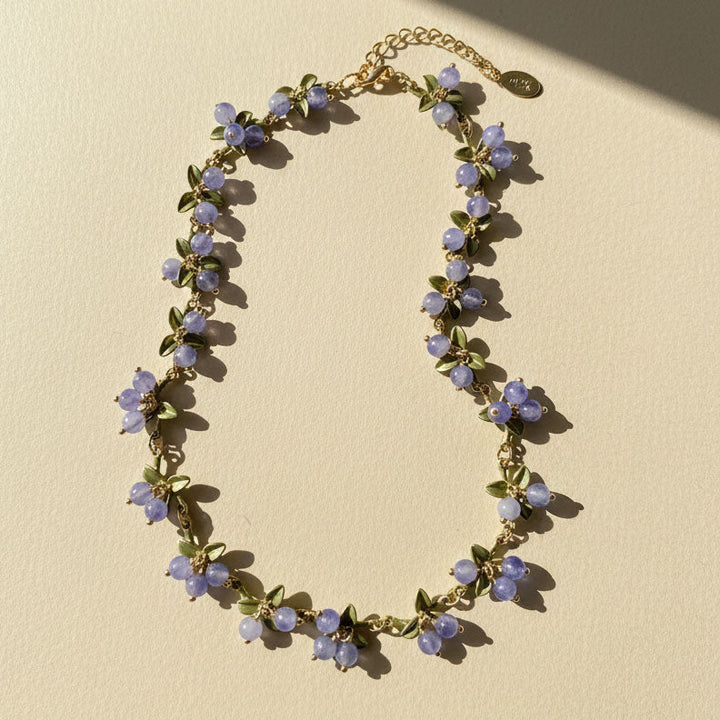 Necklace with purple floral beads on a beige background