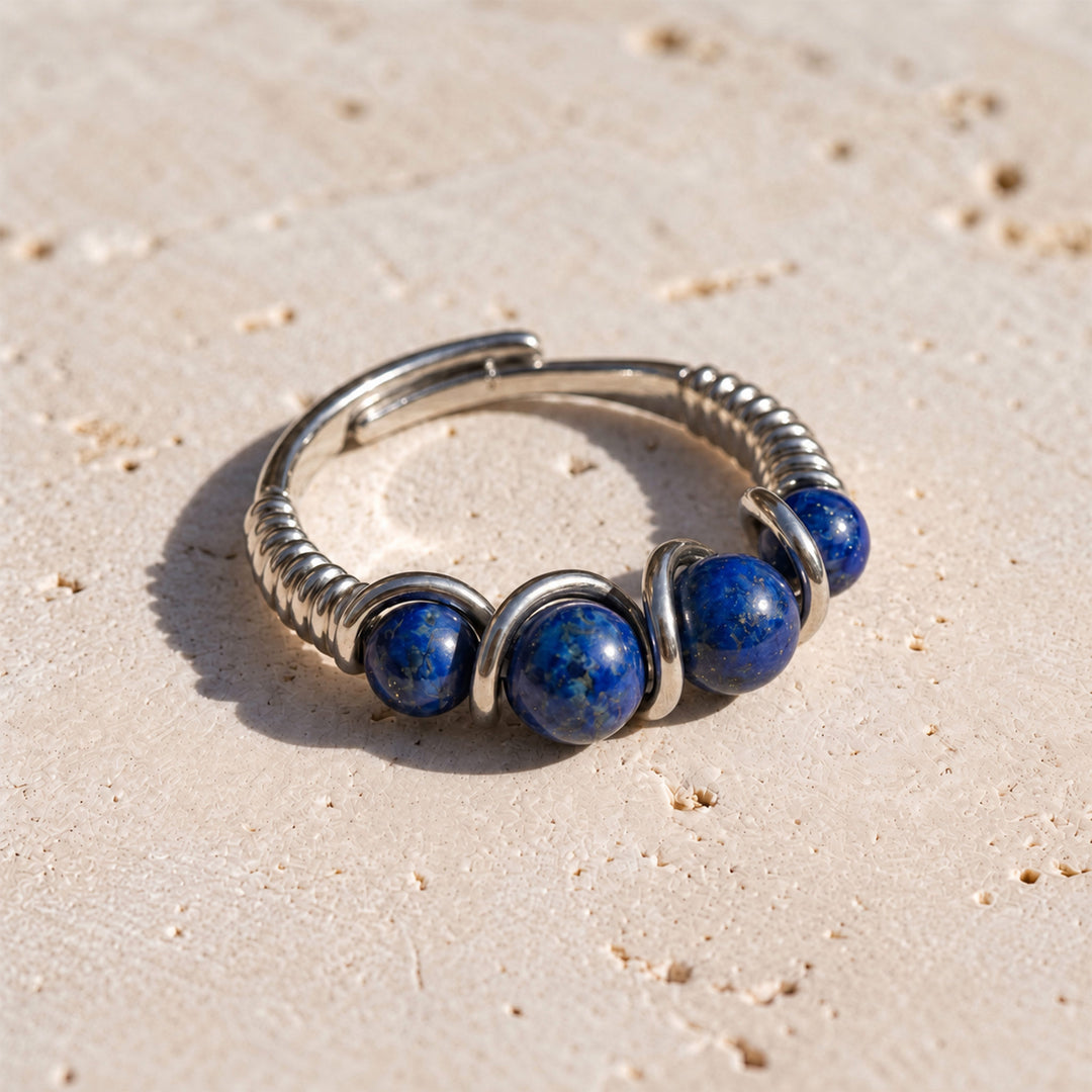 Lapis Lazuli adjustable 925 silver ring with graduated blue gemstones displayed on limestone in sunlight