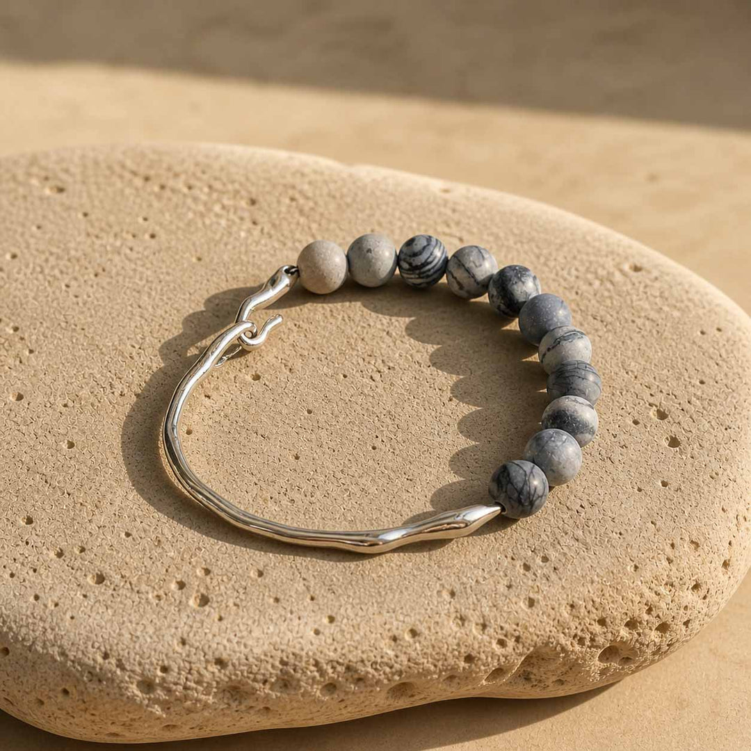 Zebra jasper bracelet with stainless steel sculptural hook on natural stone surface
