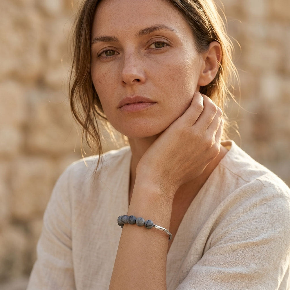 Woman wearing zebra jasper beaded bracelet with sculptural stainless steel detail