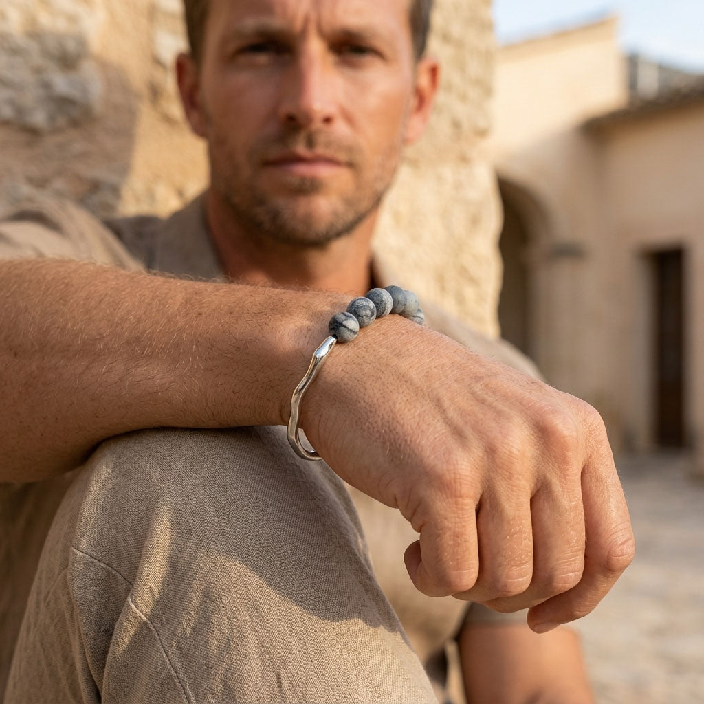 Man wearing zebra jasper bracelet with matte gemstone beads and steel hook