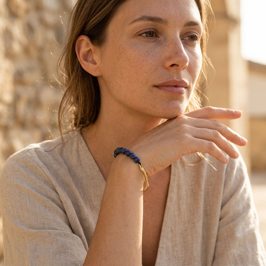 Woman wearing minimalist lapis lazuli beaded bracelet with gold accents