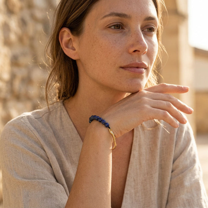 Woman wearing minimalist lapis lazuli beaded bracelet with gold accents