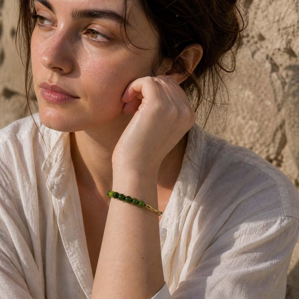 Woman wearing green chalcedony beaded bracelet with gold hook detail