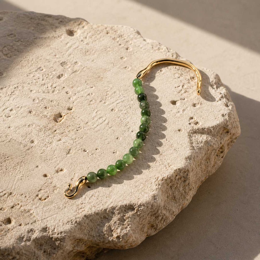 Green chalcedony bracelet styled on natural beige stone slab