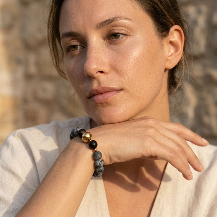 Woman wearing zebra jasper and black onyx beaded bracelet with gold accents