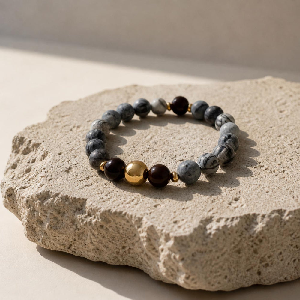 Zebra jasper and black onyx bracelet on textured natural stone surface