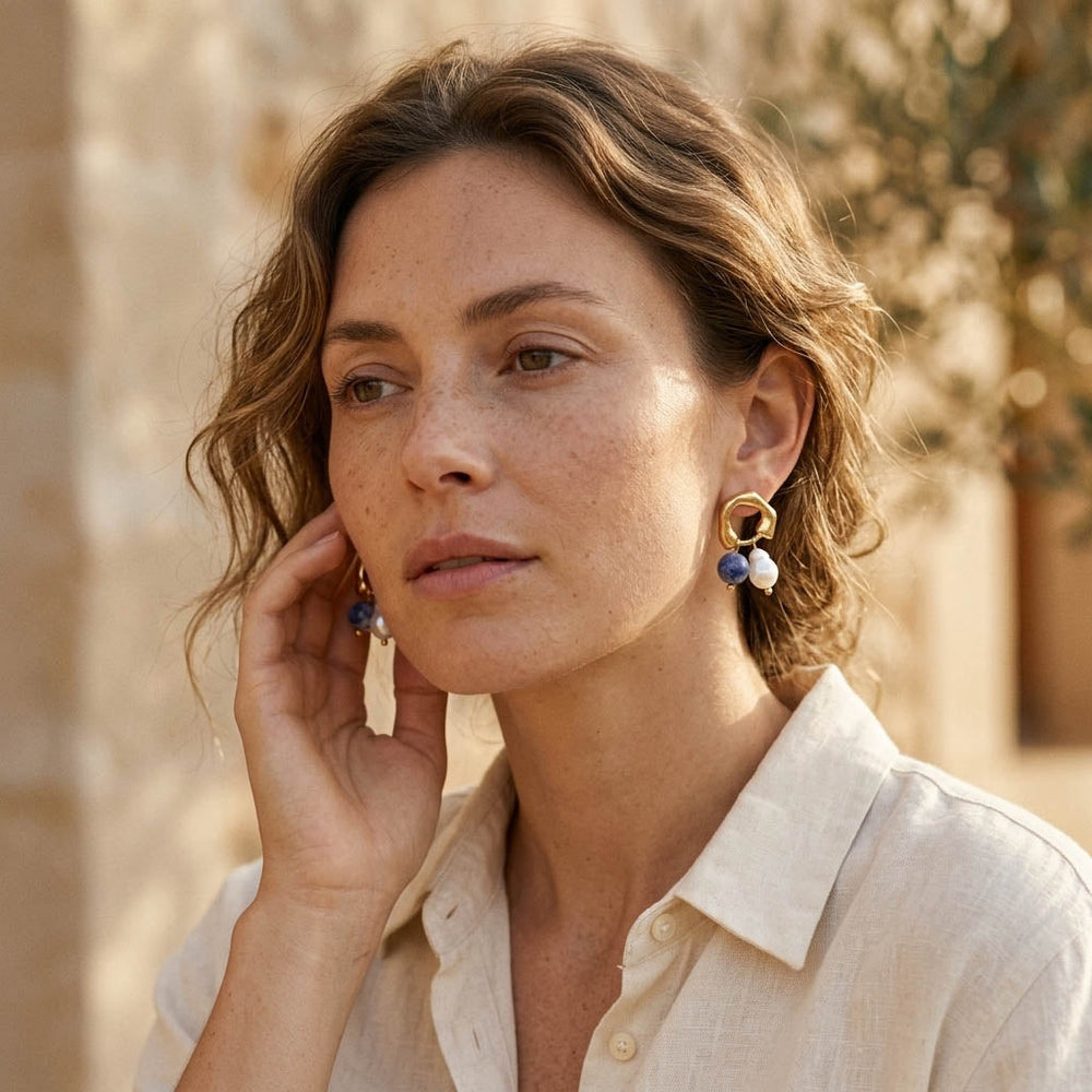 Model wearing sodalite pearl drop earrings in warm sunlight