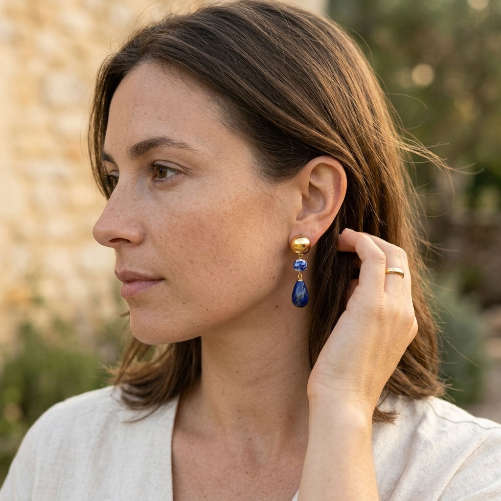 Woman wearing lapis lazuli porcelain drop earrings with gold details