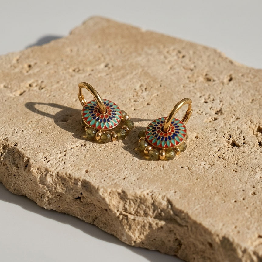 Enamel and green gemstone convertible hoop earrings on sunlit stone