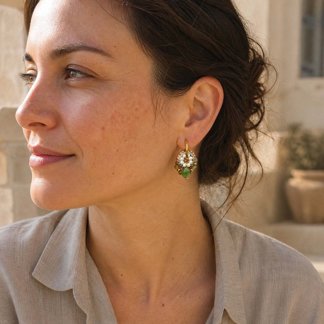Woman wearing green garnet pearl convertible hoop earrings in natural light outdoors