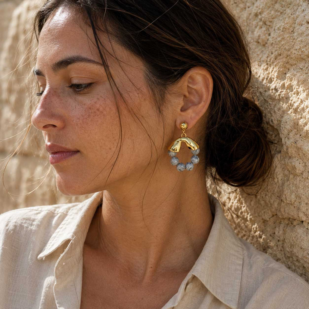 Woman wearing Map Jasper gold hoop earrings