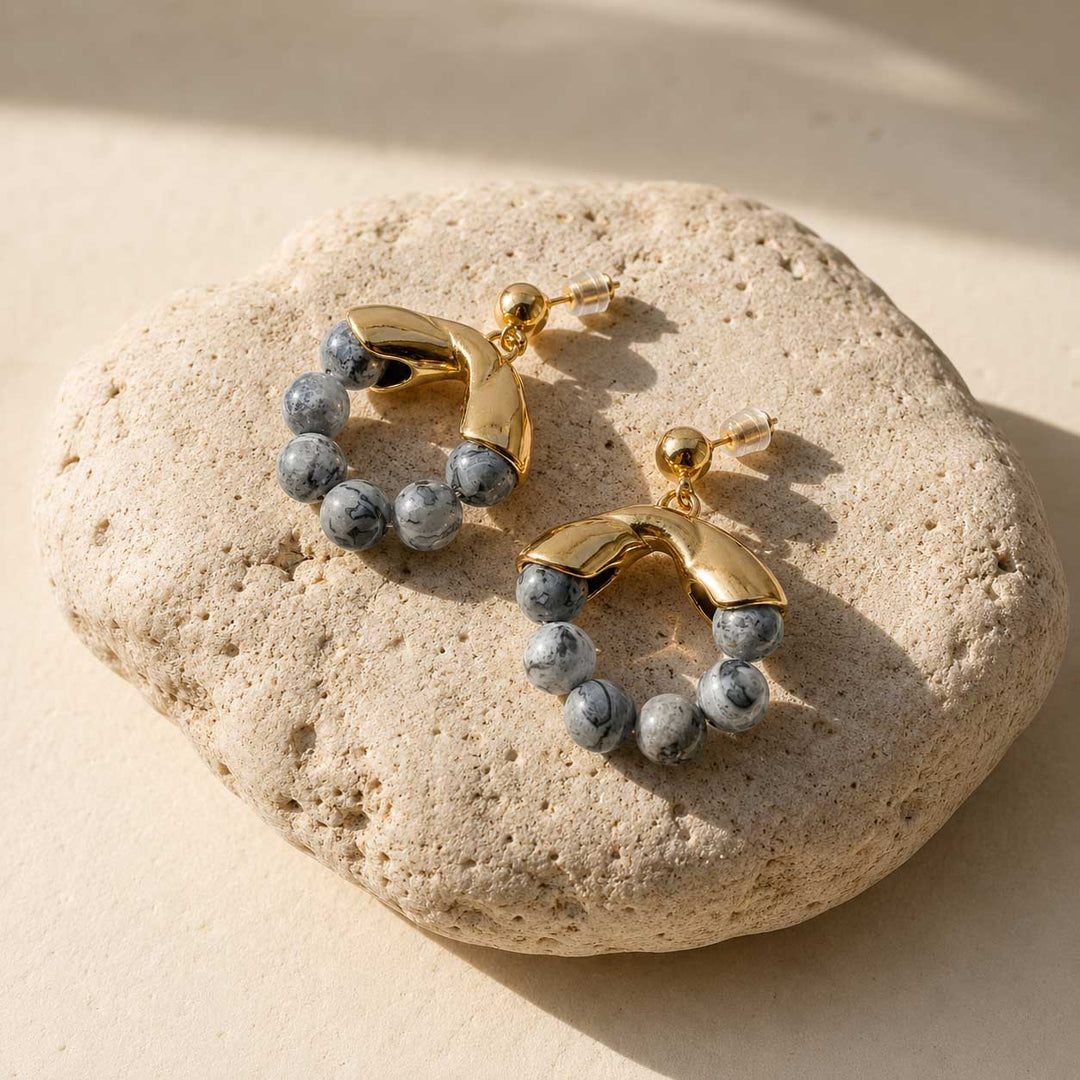 Map Jasper hoop earrings on a beige stone surface