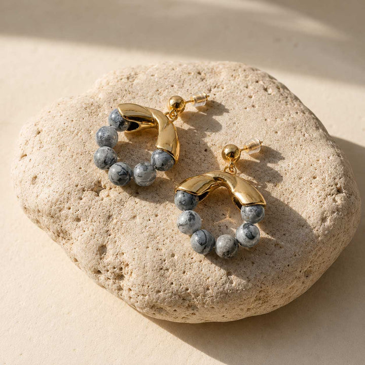 Map Jasper hoop earrings on a beige stone surface