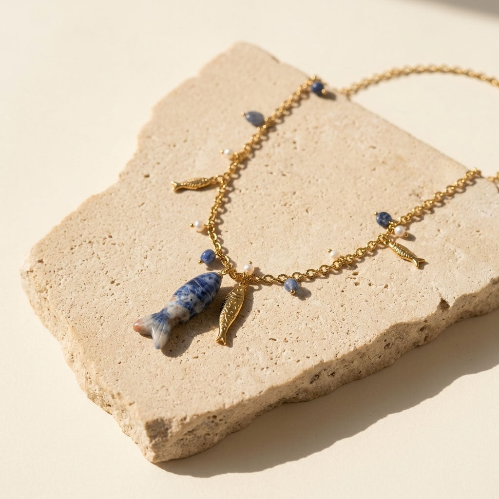 Sodalite fish pendant necklace on sunlit natural stone