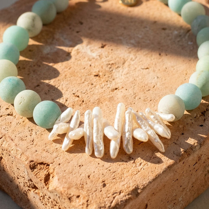 Amazonite bead and baroque pearl necklace on stone surface