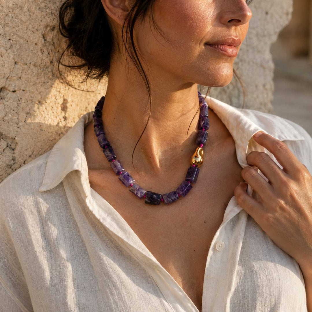 Model wearing the A2K London amethyst sculptural necklace with natural amethyst gemstone beads and an organic gold PVD stainless steel accent.