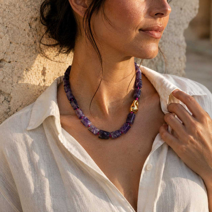 Model wearing the A2K London amethyst sculptural necklace with natural amethyst gemstone beads and an organic gold PVD stainless steel accent.